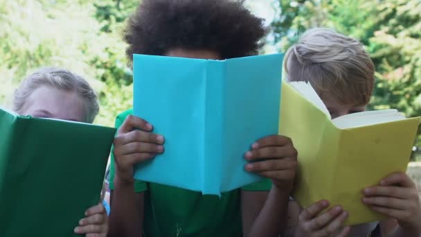 Dzieci wielorasowe czytające kolorowe książki, edukacja dzieci w wieku szkolnym — Wideo stockowe