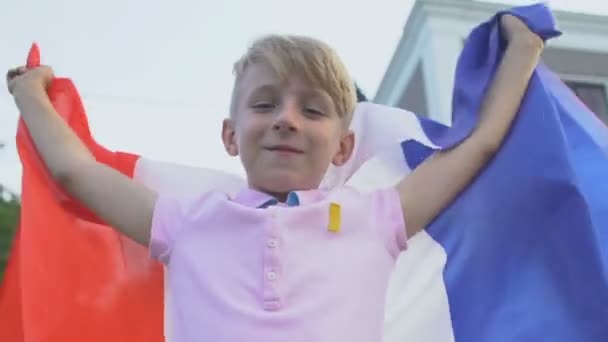 Vrolijk kind patriot met Franse vlag uitziende camera, wroeten voor sport team — Stockvideo