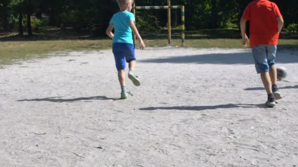 Correr niños varones golpeando el fútbol al aire libre jugando juntos, deporte — Vídeos de Stock