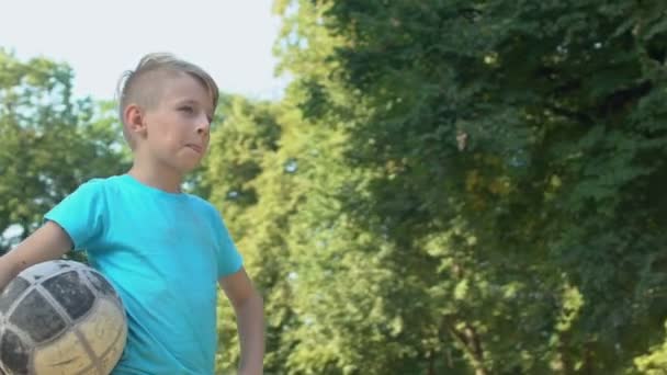 Menino masculino segurando futebol de pé estádio quintal, esporte hobby, exercício regular — Vídeo de Stock