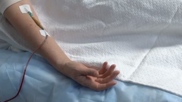 Неизлечимо больные пациенты рука конвульсирует, капельница в руке, человек страдает болью — стоковое видео