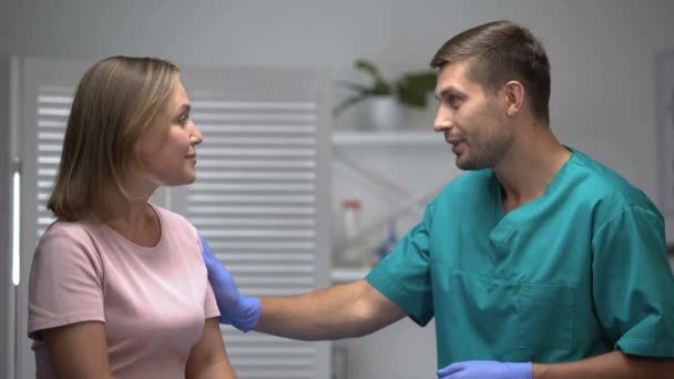 Gondoskodó férfi orvos beszél a jó elemzési eredmények a női beteg — Stock videók