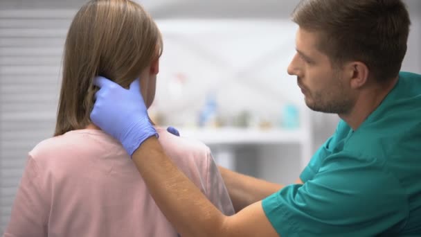 Traumatologista masculino examinando o pescoço do paciente feminino, inflamação e entorse — Vídeo de Stock