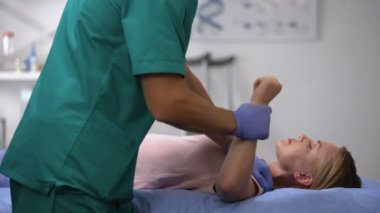 Travma rehabilitasyon döneminden sonra kadın hasta elini çalıştırıyor.