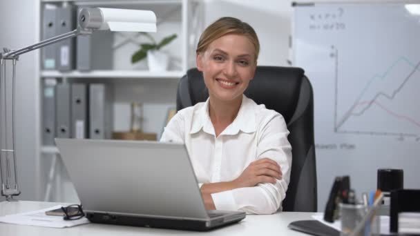 魅力的なビジネス女性のオフィスに座ってカメラに笑みを浮かべて、成功、リーダー — ストック動画