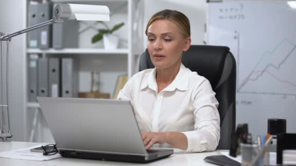 Žena šéf masáže spánky pracuje na notebooku, trpí bolestí hlavy stresující práce — Stock video