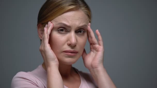 Zaniepokojona kobieta masuje świątynie czując straszny ból głowy, migrena, pms — Wideo stockowe