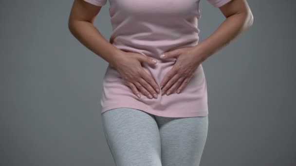 Woman writhing from pain in lower abdomen, menstrual pain, risk of miscarriage — Stock Video