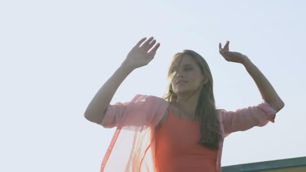 Senhora atraente dançando na festa no telhado, sorrindo e fazendo movimentos femininos — Vídeo de Stock