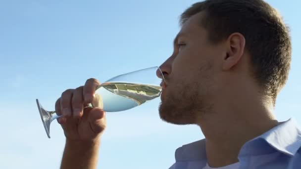 Όμορφος νεαρός άνδρας πίνοντας ένα ποτήρι κρασί στο πάρτι, γιορτάζοντας την επιτυχία αργή-mo — Αρχείο Βίντεο
