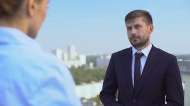 Erkek ve kadın yöneticiler ofis terasında iş ve ortaklık kariyerini tartışıyor