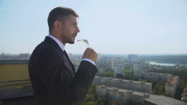 Hombre gerente disfrutando de la vista de la ciudad en la azotea beber copa de champán, celebración — Vídeos de Stock