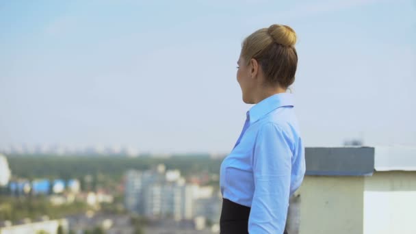 Cheerful female manager enjoying cityscape standing office terrace, work break — Stock Video