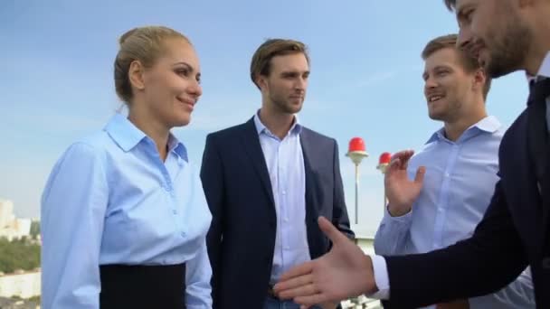 İş kadını ve erkek el sıkışıyor, iş arkadaşları kutlama anlaşmasını alkışlıyor — Stok video