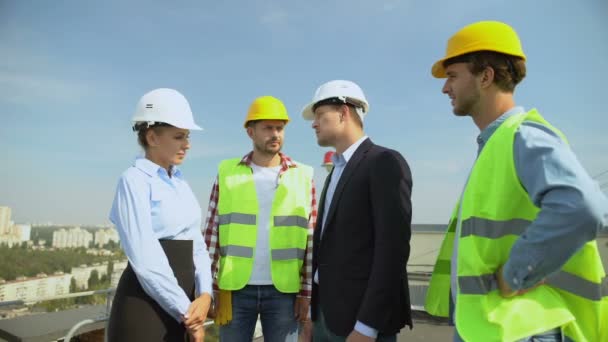 Young man in suit shaking female contractor hand standing building roof, service — Stock Video