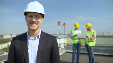 Güvenlik miğferi takmış gülümseyen inşaat mühendisi kamera, yetenekli mimar.