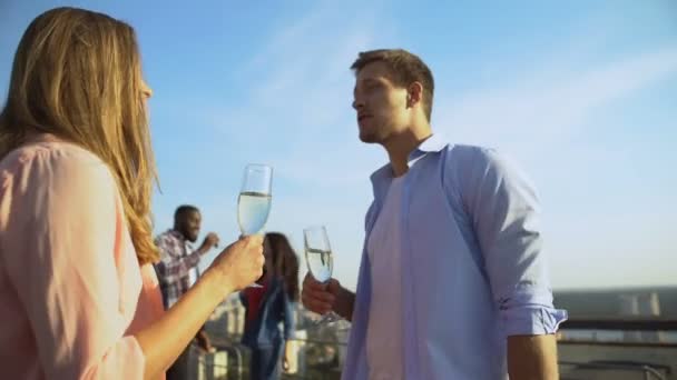 Hermosa pareja caucásica bebiendo champán y conociéndose en la fiesta — Vídeo de stock