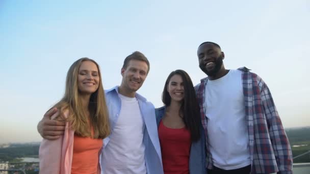 Companhia de amigos multirraciais rindo da câmera, relaxando juntos ao ar livre — Vídeo de Stock