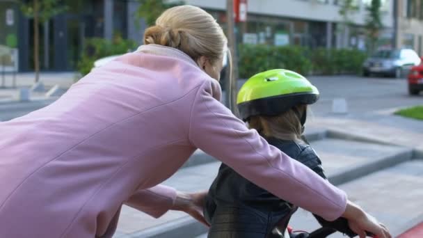 Amare la madre aiuta la figlia a imparare ad andare in bicicletta all'aperto, connessione — Video Stock