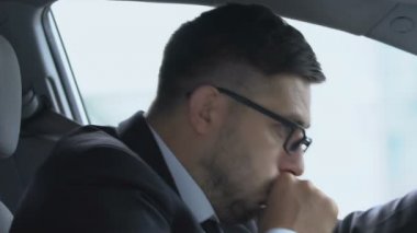Arabada öksüren erkek sürücü, virüs yüzünden boğaz ağrısı, sağlık sorunları.