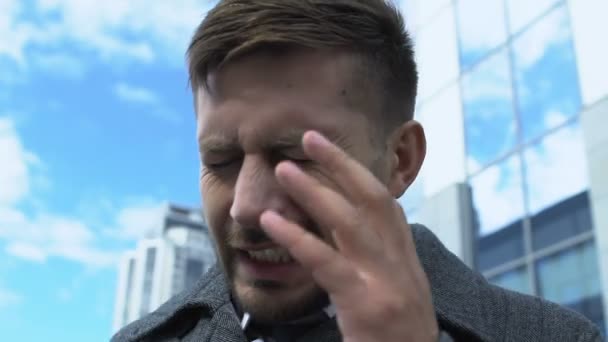 Уставший бизнесмен, у которого острый приступ боли на улице, головная боль, вызванная стрессом — стоковое видео