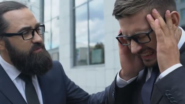 Partnerzy omawiający interesy, człowiek cierpiący na silny ból głowy na spotkaniu, stres — Wideo stockowe