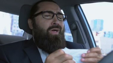 Hasta yetişkin bir adamın arabada hapşırması, alerji sağlık sorunları, şehirde grip salgını