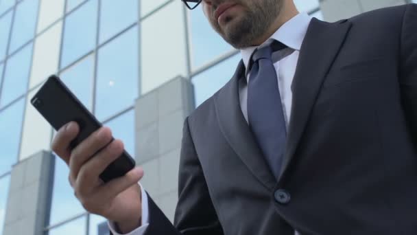 Hombre ocupado en traje escribiendo mensaje en el teléfono inteligente utilizando la aplicación móvil de negocios al aire libre — Vídeos de Stock