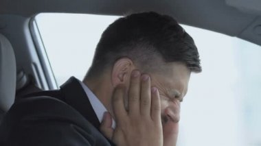Yetişkin bir adam keskin kulak ağrısı çekiyor. Kapalı araba, kulak iltihabı medya hastalığı, sağlık sorunları.