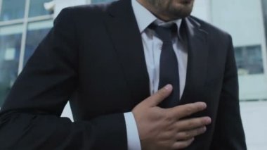 Yorgun bir iş adamı sokakta kalp krizi geçiriyor, göğüs ağrısı, stresli bir hayat.