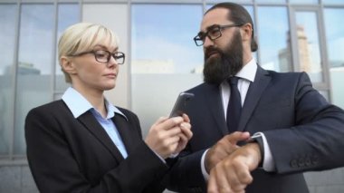 Erkek patron kadın asistanı, sekreter akıllı telefondan notlar alıyor.
