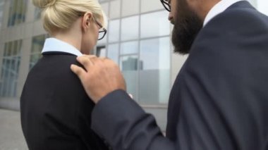 Erkek iş toplantısında kadına omuz omuza dokunuyor, kadın tacizciyi itiyor.