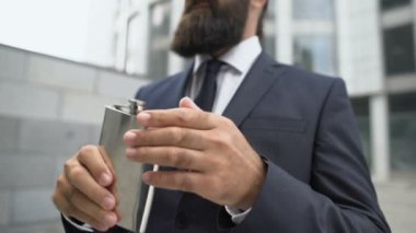 Ofis binasının yakınında alkol içen sıkıntılı işadamı, iş yerinde bitap düşmüş.