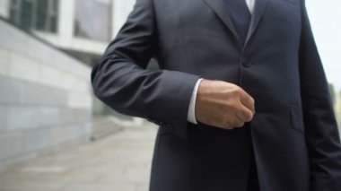 İş adamı başarılı bir iş görüşmesinden sonra yumruğunu sıkıyor, sonuçtan gurur duyuyor