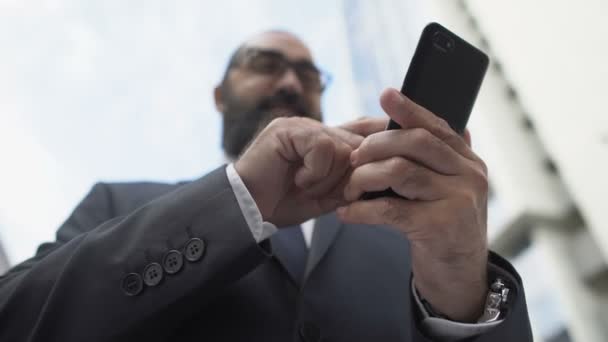 Homme d'affaires prospère défilement smartphone à l'extérieur, en utilisant l'application mobile sur gadget — Video