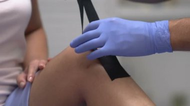 Spor doktoru ağrılı hasta dizine bant takıyor, travma rehabilitasyonu...