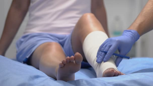 Arts controleren van de patiënt been in elastisch verband, schrijven onderzoek resultaat — Stockvideo