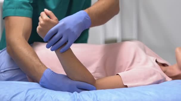 Traumatólogo moviendo brazo de paciente femenino, rehabilitación después de trauma articular — Vídeos de Stock