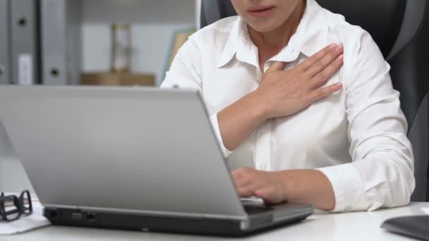 Женщина-босс работает на ноутбуке едва дышит, боль в груди, риск сердечного приступа — стоковое видео