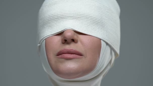 Mujer cubierta con vendaje elástico que muestra signo de silencio, cirugía plástica ilegal — Vídeos de Stock