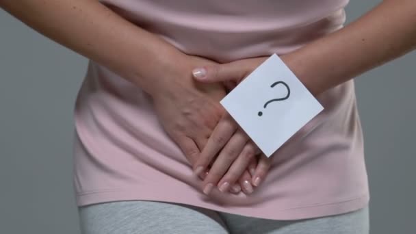 Kobieta ze znakiem zapytania trzymająca dolny brzuch, cierpiąca na ból, zapalenie pęcherza moczowego — Wideo stockowe