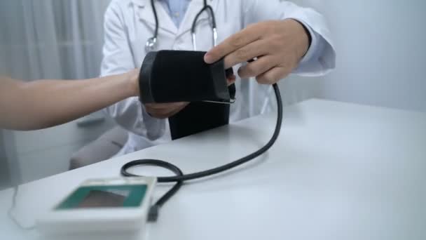 Врач измеряет давление на пациента с жалобами, здравоохранением и диагностикой — стоковое видео