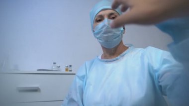 Ameliyattan önce gergin. Kadın cerrahın elini tutuyor. Güven ve umut.