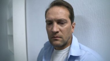 Hastane koridorunda dikilen yorgun adam ameliyatın bitmesini bekliyor. Gerginlik var.