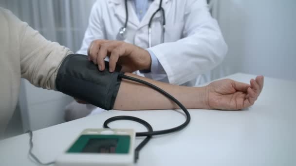 Medico fiducioso che controlla la pressione sanguigna del paziente e dà consigli, salute — Video Stock