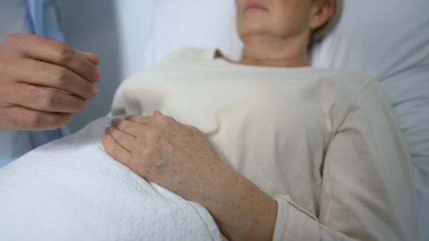 Loving son supporting and comforting terminally-ill mother in her hospital ward — Stock Video