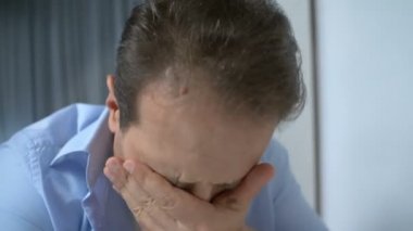 Hüsrana uğramış adam hastane koğuşunda ağlıyor, acı çekiyor, sağlık sorunları var.