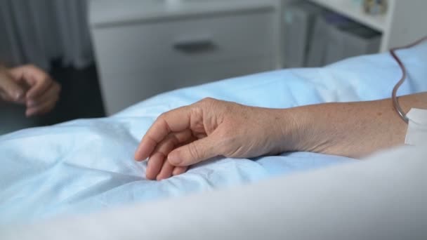 Zorgzame dochter hand in hand van terminaal zieke moeder met chemotherapie druppelaar — Stockvideo