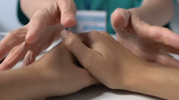 Медичний працівник втішає пацієнта торкаючись рук на столі поганий діагноз, хвороба — стокове відео