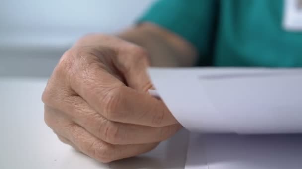 Travailleur de laboratoire regardant à travers les résultats d'analyse et mettant des lunettes sur la table — Video